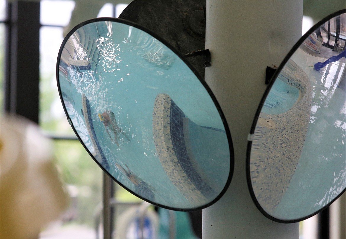 A student and instructor in adult swim lessons at the Kroc Center are reflected in a mirror Wednesday.