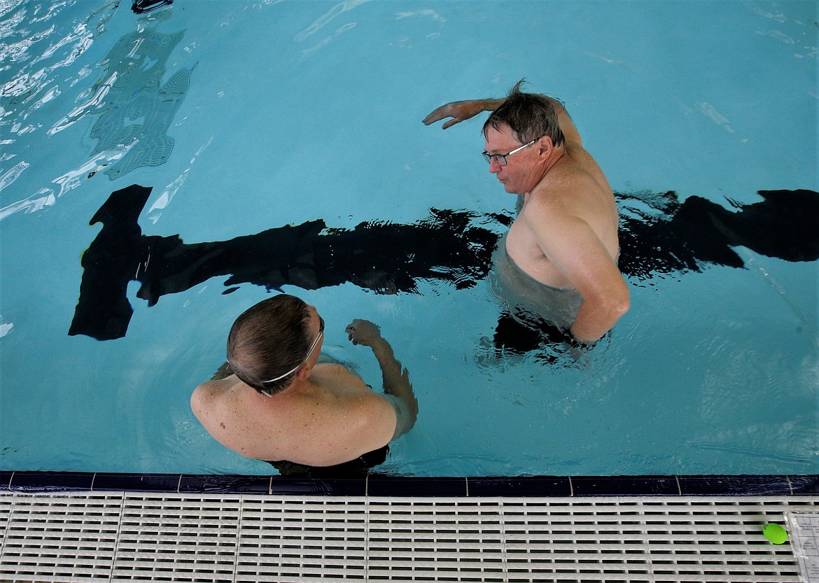 Glenn Mabile, right, volunteer instructor, shows Nick Vendetti swimming techniques at the Kroc Center during adult swim lessons Wednesday.