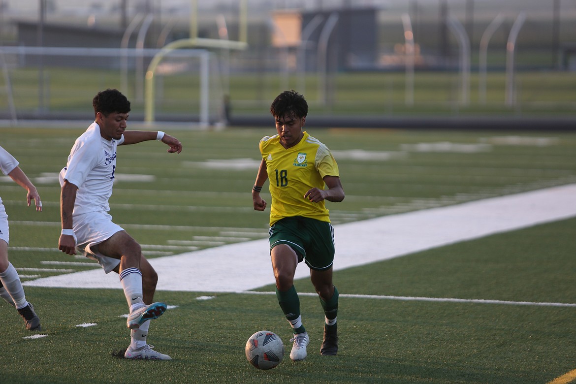 Quincy senior Edgar Guzman, right, rushes upfield with possession of the ball against Connell on Friday.