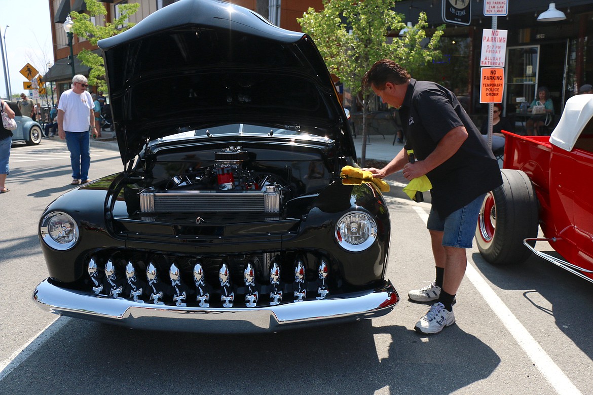 Rick Wowk wips a smudge from his car as he waits for fans to stop by to admire the classic he modified into his dream car.