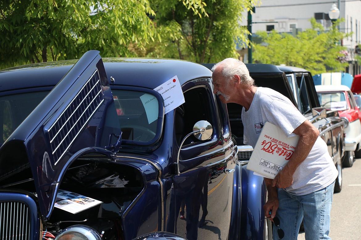 A judge checks out a car during Saturday's Lost in the '50s car show.