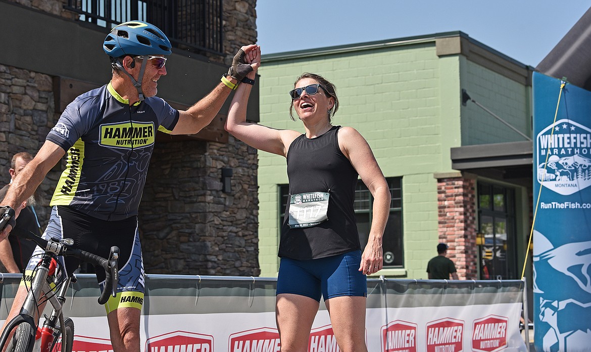 Elizabeth Paddock, the top female finisher in the Whitefish Marathon, gets a high five from a pacer at the finish line. (Julie Engler/Whitefish Pilot)