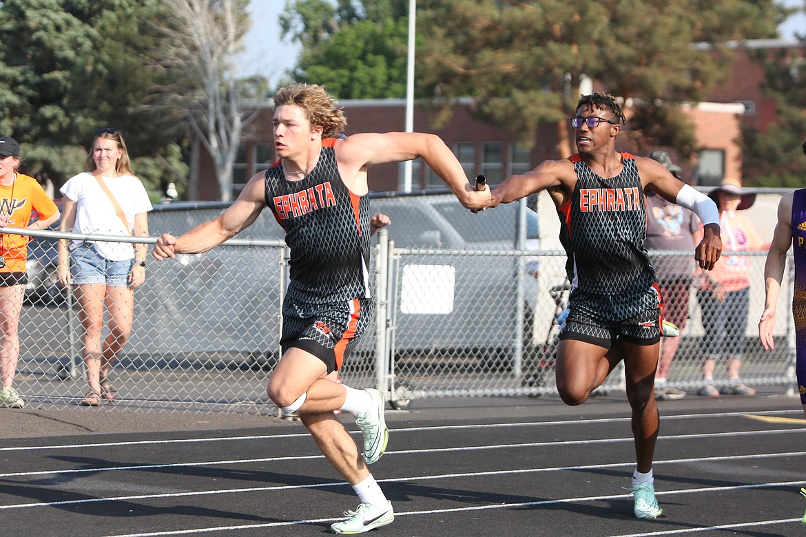 Ephrata senior Tyler Raine, right, passes the baton to fellow Ephrata senior Travis Hendrick, left, during the boys 4x100-meter relay. Ephrata finished second in the relay with a time of 42.69 seconds.