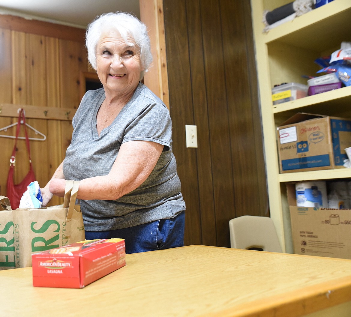 Libby Food Pantry volunteer Betsy Miller organizes food items for distribution on Tuesday, May 16. (Scott Shindledecker/The Western News)