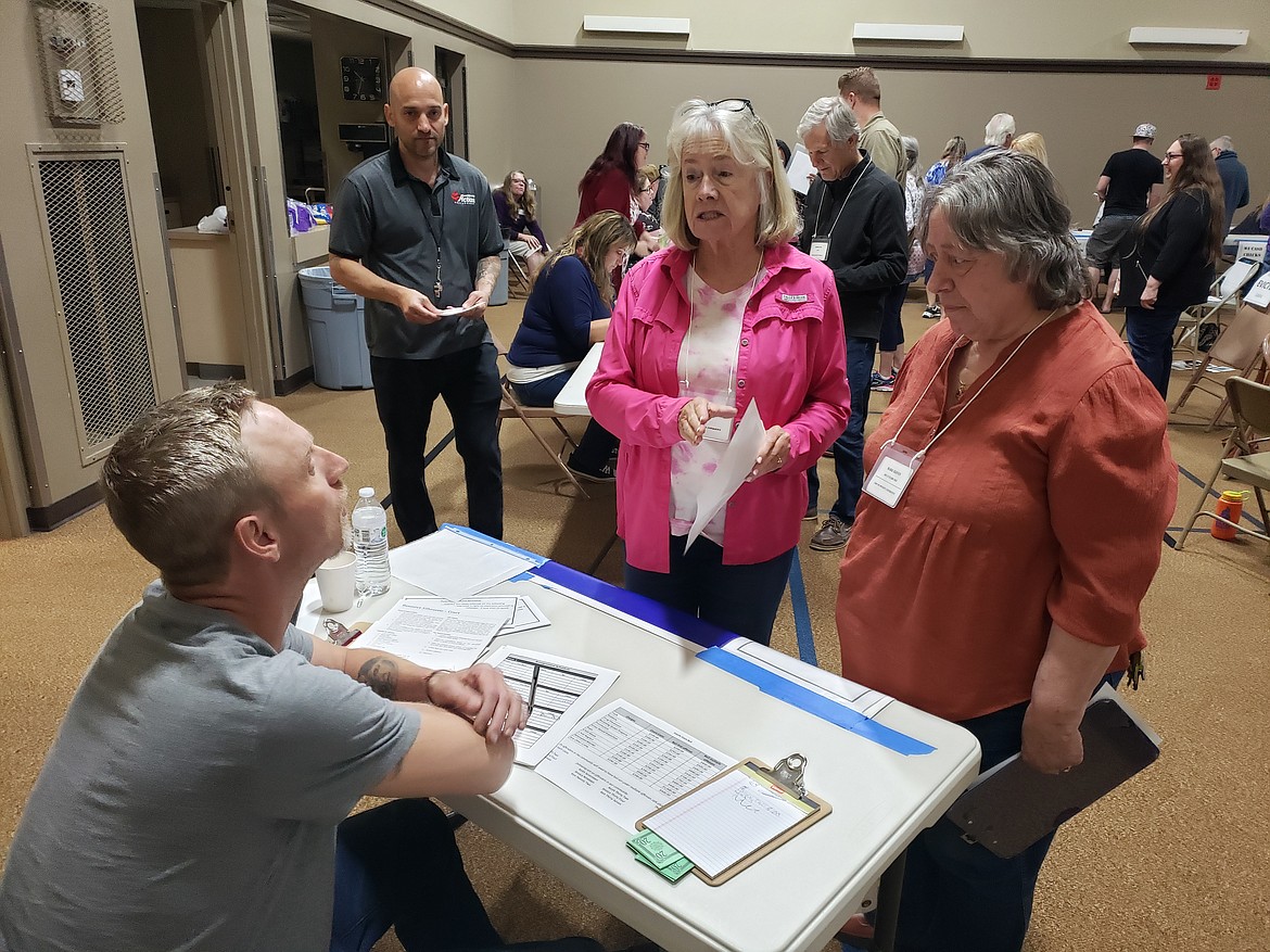 Karen Grace, center, tries to negotiate with the "judge" Tuesday in a Cost of Poverty Experience at First Presbyterian Church in Coeur d'Alene. During the simulation, Grace "went to jail" for not having enough money.