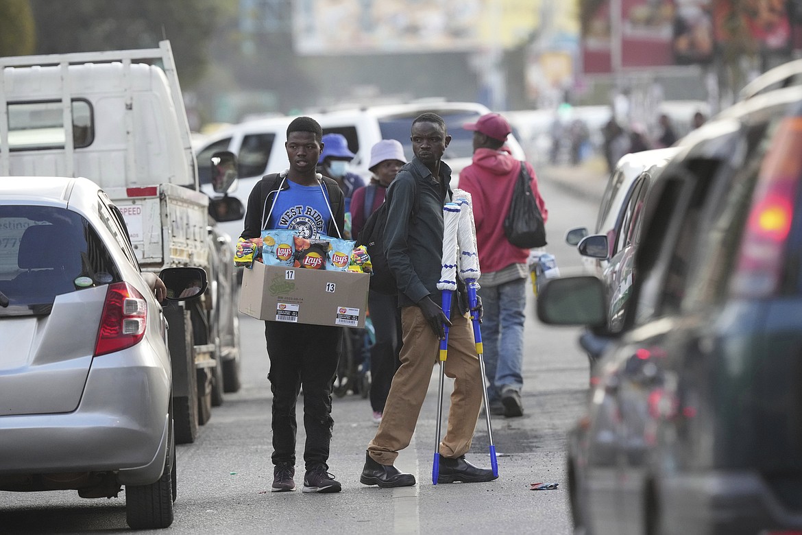 Street traders sell various goods to motorists on the streets of Harare, in this May, 10, 2023 photo. Shoppers in Zimbabwe are increasingly turning to street traders to buy what they need as the local currency plunges in value against the U.S. dollar. Street traders in cars, on bicycles or on foot clog sidewalks, roads and parking spaces. They sell items ranging from groceries to cosmetics, brooms, dog chains, car parts and medicines. ( AP Photo/Tsvangirayi Mukwazhi)