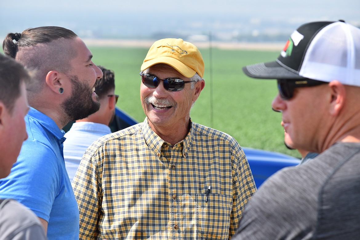 Pasco-area orchardist Denny Hayden (center) talks with Altitude Agri Service drone pilot Charlie Lautenbacher, a former U.S. Army drone pilot for six years, following WSU’s Spring Drone Day event at Hayden’s orchard.