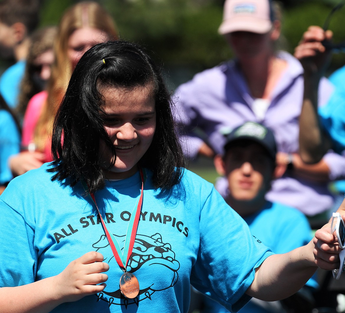 A student smiles with joy as she receives her medal during the awards ceremony.