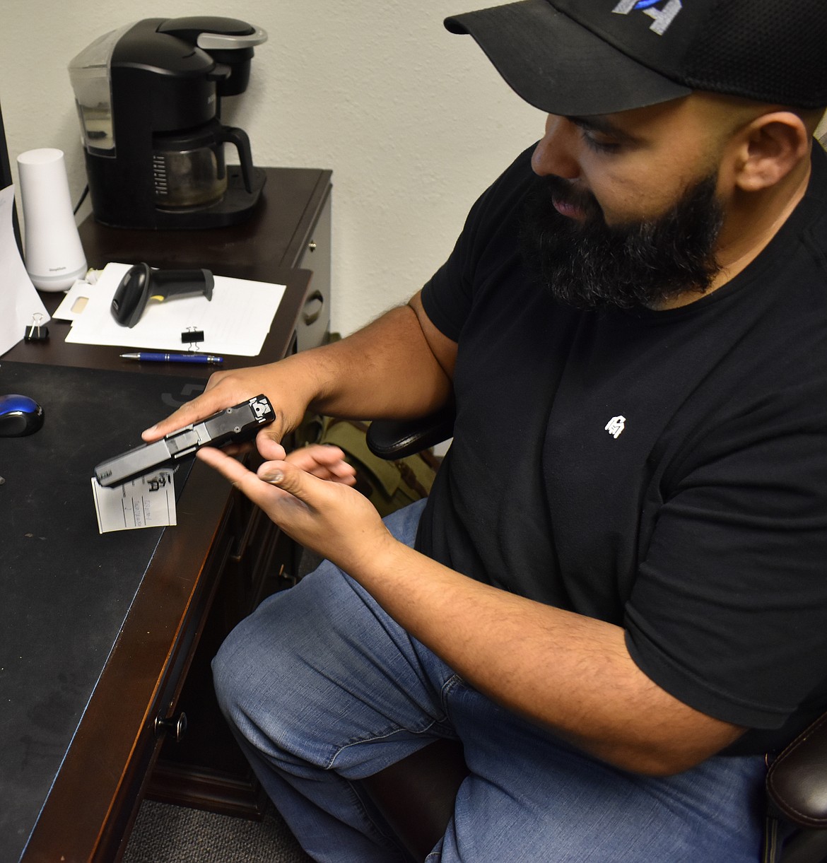 Firearm safety instructor Edgar Salazar shows the right way to take out and put away a handgun – carefully.