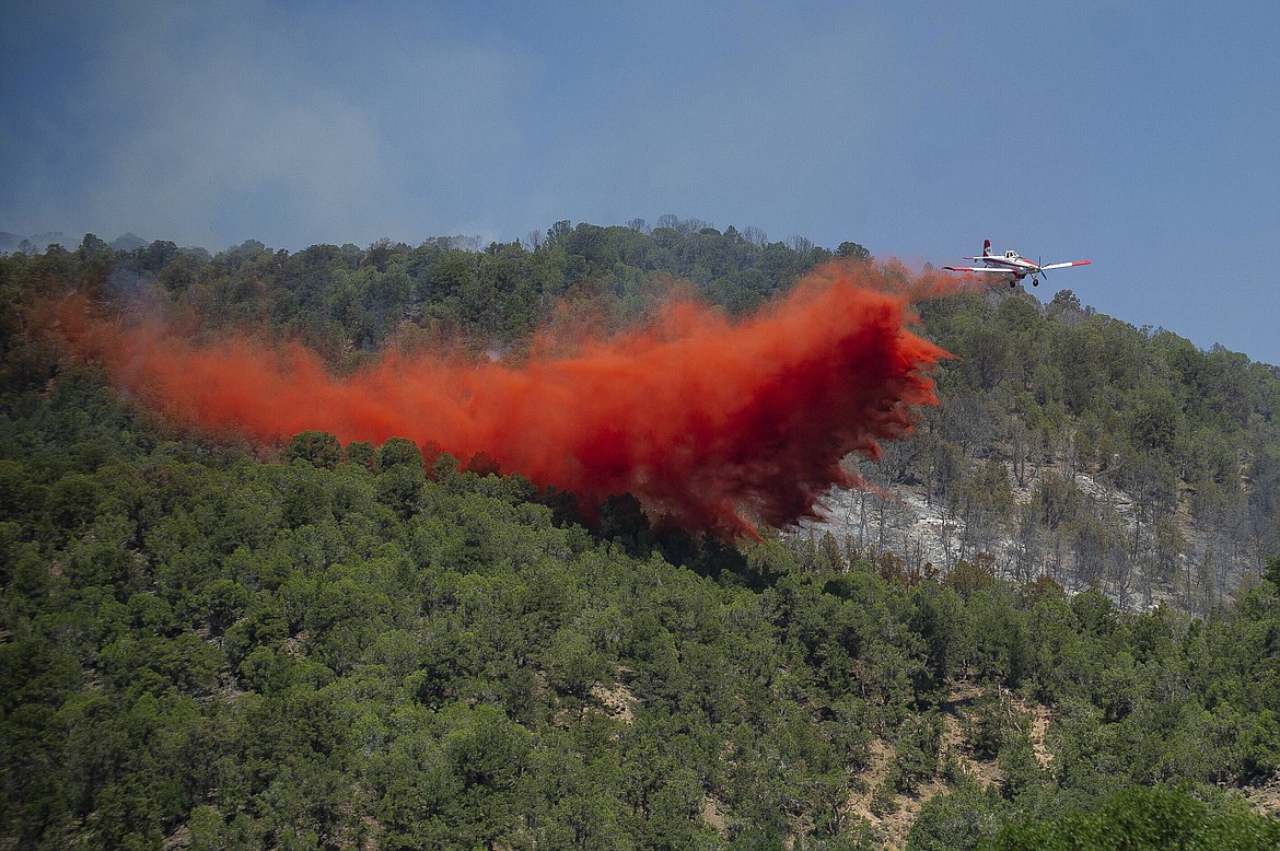 A plane drops fire retardant near the Lake Christine wildfire on July 4, 2018, in Basalt, Colo. A federal judge said Friday, May 26, 2023, that chemical retardant dropped on wildfires by the U.S. Forest Service is polluting streams in western states in violation of federal law, but said it can keep being use to fight fires. (Anna Stonehouse/The Aspen Times via AP, File)