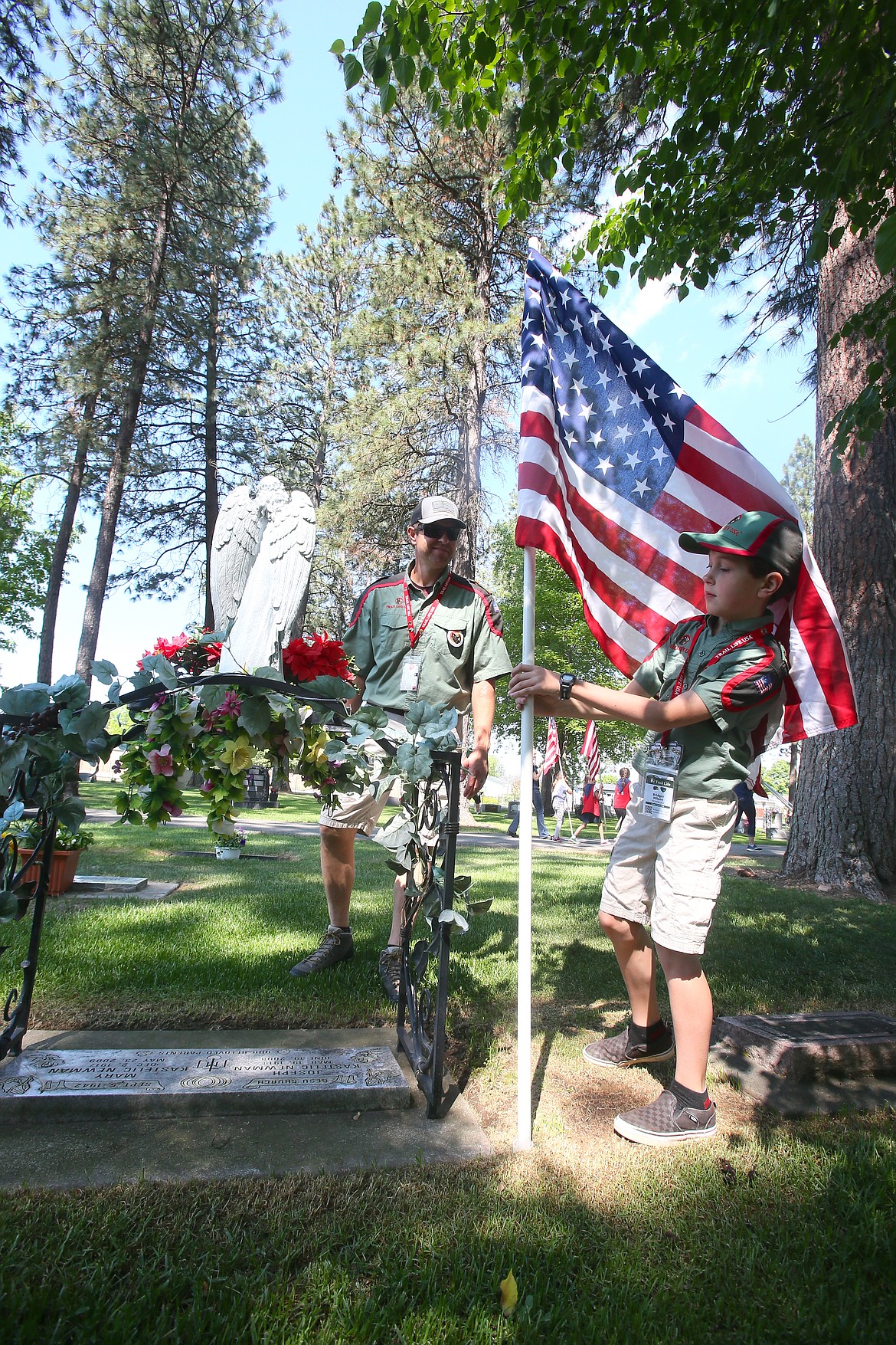 Trail Life USA patrol member Bridger Wilson, 9, secures an American flag at a gravesite as he and his dad, Brent Wilson, help place more than 600 flags in Evergreen Cemetery. The annual flag placement on veteran and military graves ahead of Memorial Day is coordinated by the Post Falls American Legion Post 143. The city of Post Falls and the Legion will host a Memorial Day ceremony in the cemetery at 11 a.m. Monday. Evergreen Cemetery is at 2834 N. Spokane St.