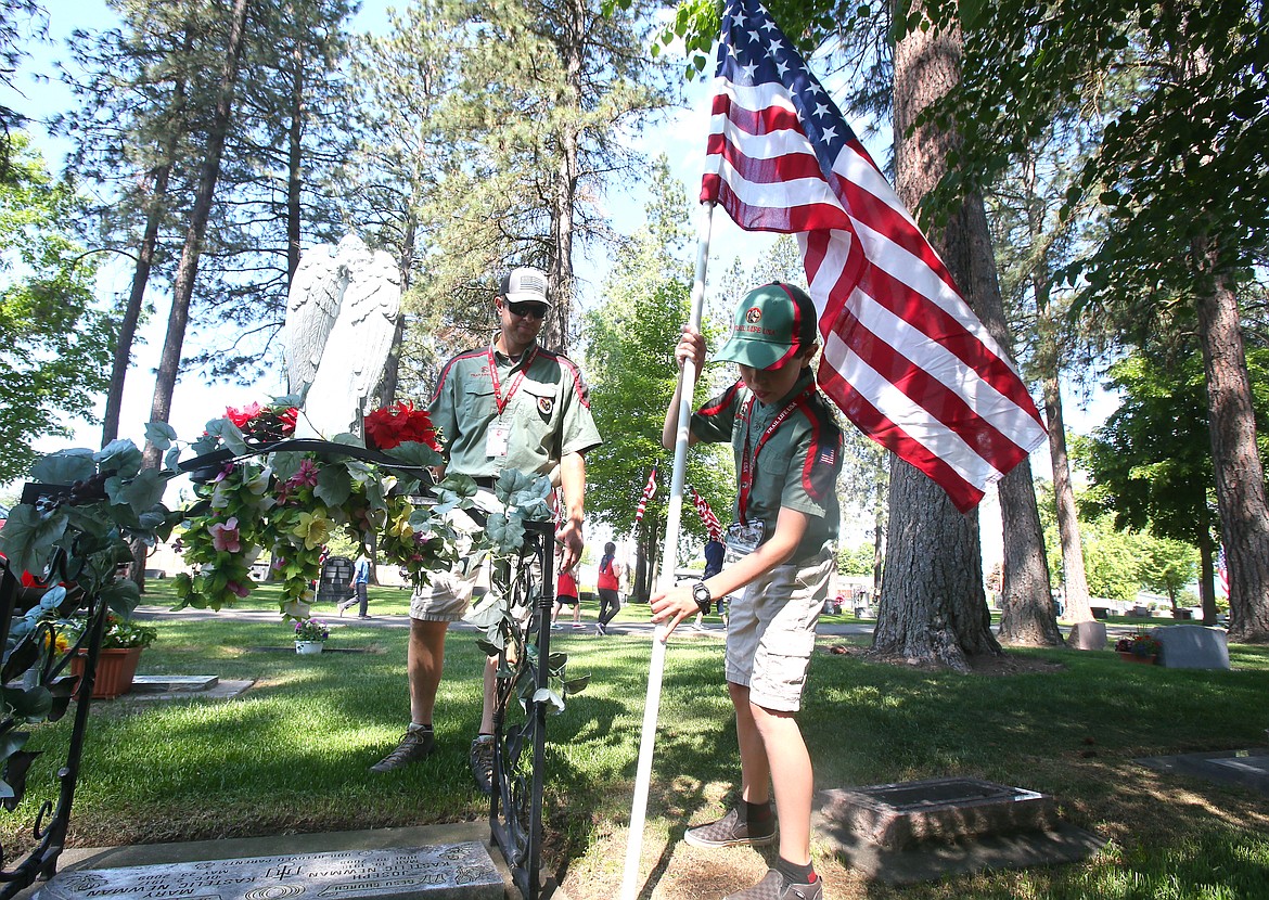Trail Life USA patrol member Bridger Wilson, 9, secures an American flag at a gravesite Friday as he and his dad, Brent Wilson, help place more than 600 flags in Evergreen Cemetery. The annual flag placement on veteran and military graves ahead of Memorial Day is coordinated by the Post Falls American Legion Post 143. The city of Post Falls and the Legion will host a Memorial Day ceremony in the cemetery at 11 a.m. Monday. Evergreen Cemetery is at 2834 N. Spokane St.