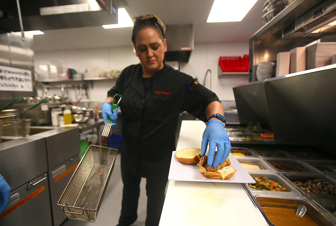 Sous-chef and pastry chef Arielle Padel preps a fried chicken sandwich Tuesday in the kitchen of Vantage Point Brewing Co. in Coeur d'Alene.
