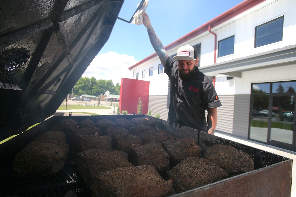 Vantage Point Brewing Co. executive chef Josh Lozano smokes tri-tips Tuesday out on the patio.