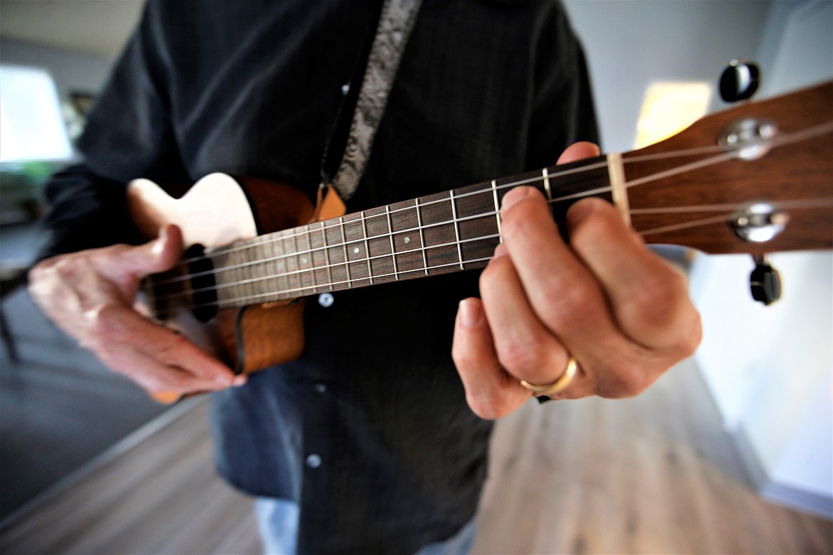 Kevin Lawrence plays a few chords on the ukulele.