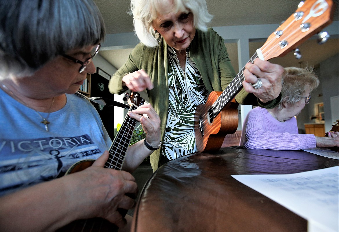Linda Shane, right, helps Terry Porret learn to play the ukulele.