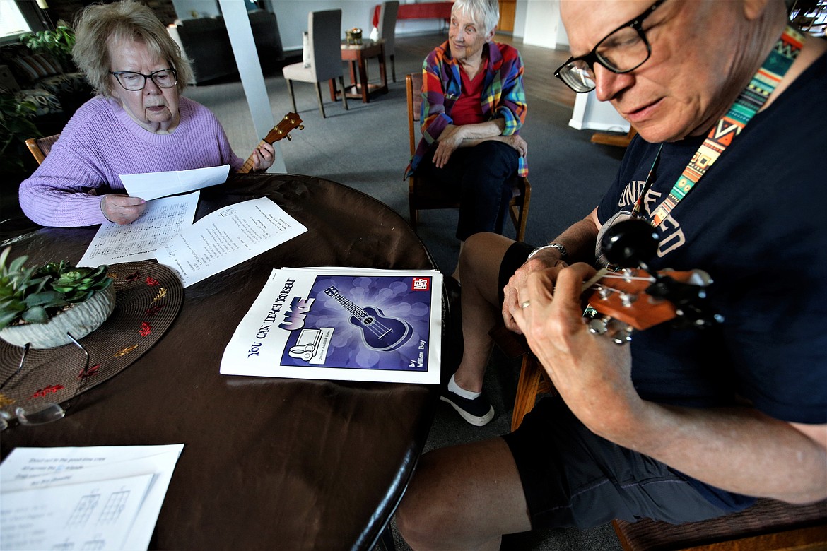 Clay Vreeland plays the ukulele during a lesson with beginners at a meeting of the Ukulele Club of Coeur d'Alene. He is joined by Catharine Owens and Rosalie Barton.