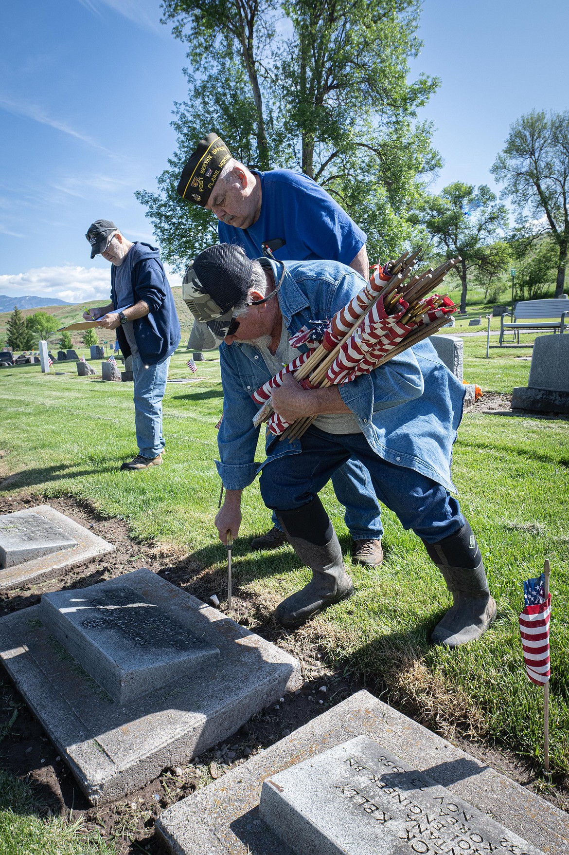 Joe Wittig, Bill Beck and Dan Johnson place flags on veteran graves. (Tracy Scott/Valley Press)