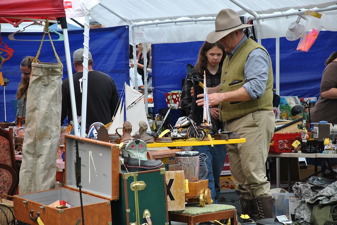 This dapper fellow takes a hard look at pair of boots like the ones he's wearing at a vendor booth during the St. Regis Flea Market on Saturday morning. (Amy Quinlivan/Mineral Independent)