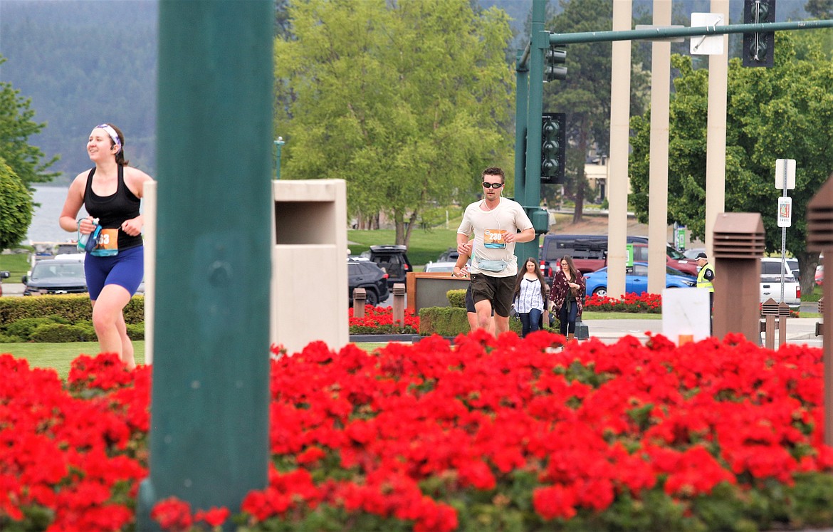Runners pass the geraniums near The Coeur d'Alene Resort on Sunday.