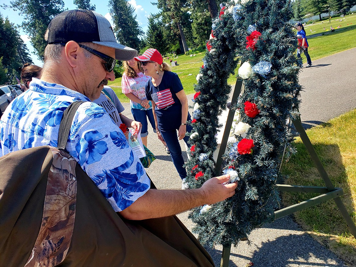 Rathdrum City Administrator Leon Duce places a poppy on the memorial wreath honoring the fallen during a Memorial Day ceremony Monday at Pinegrove cemetery.