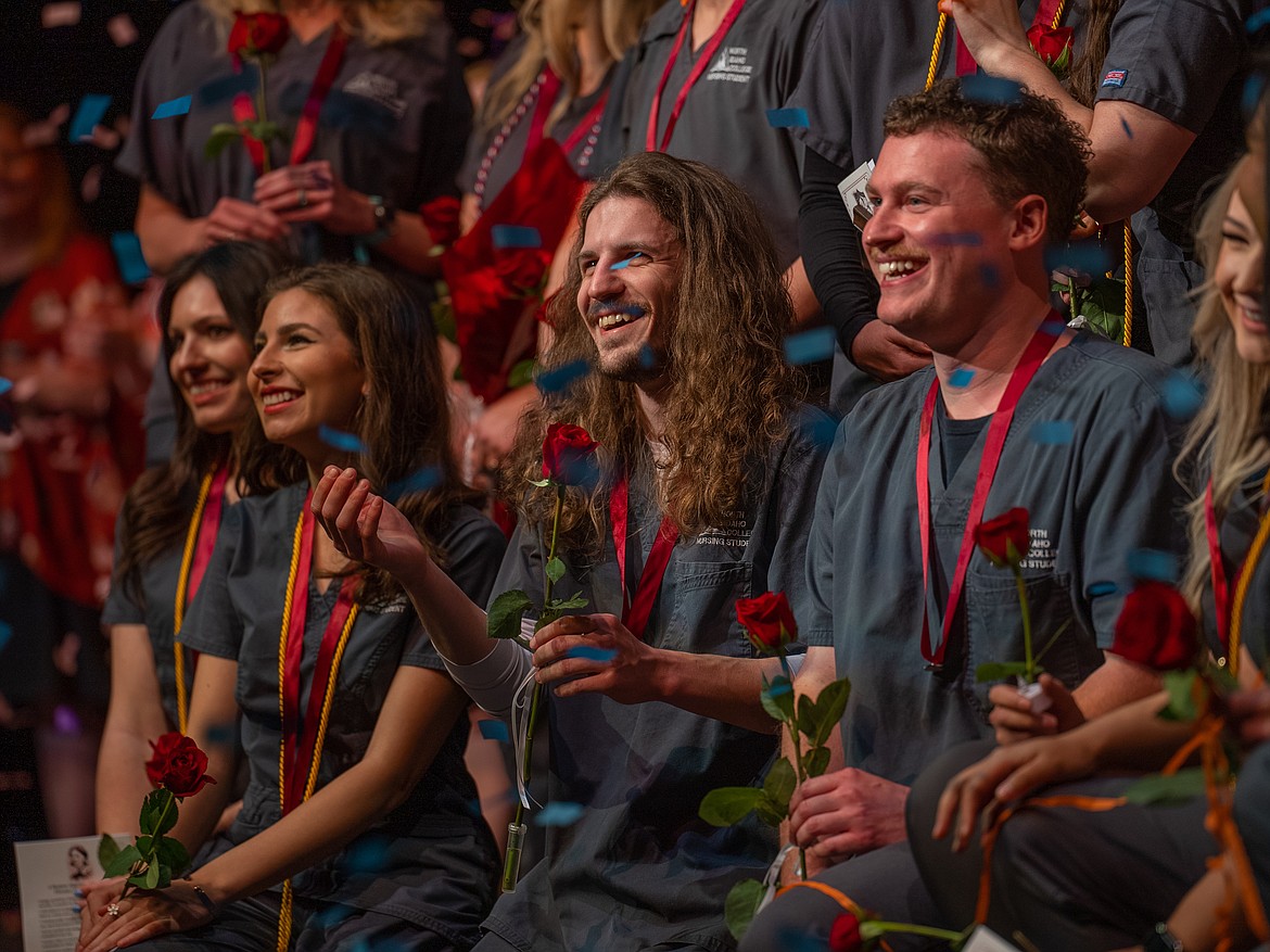 Johnathan Aston reaches for confetti onstage during the NIC Nursing program's pinning ceremony Wednesday, May 10 in Boswell Hall Schuler Performing Arts Center on NIC’s Coeur d’Alene campus.