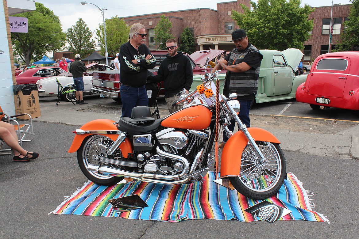 A motorcycle owner, right, shows off his bike build at the car show Saturday.