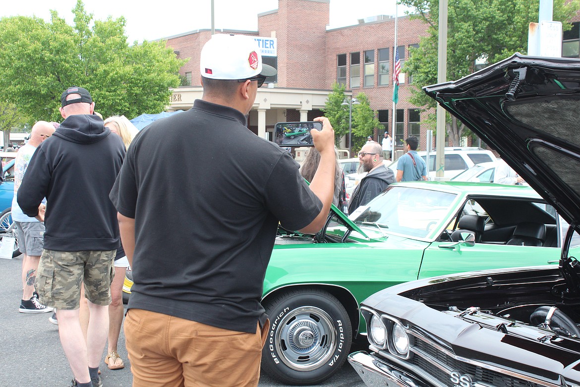 A car enthusiast snaps a picture during the Spring Festival 2023 car show Saturday.