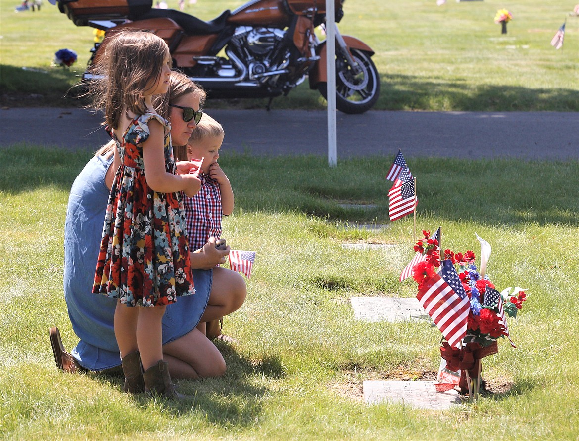 Chanel Germain is joined by children Kali and Ripley as they paused before a gravesite at Coeur d'Alene Memorial Gardens on Monday.