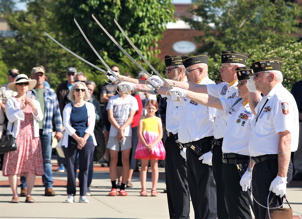 Veterans, from left, Richard Biggar, Jeff Broadhead, David Morgensen, Bob Martin and Lew Alert raise their swords during the Missing Man ceremony on Monday at Veterans Plaza at McEuen Park.