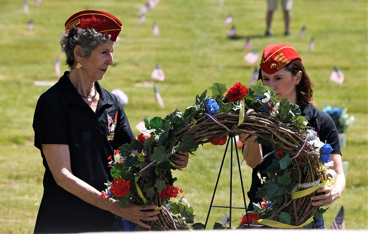 Julia Mangan, left, and Stepanie Magajna place the wreath in place at Coeur d'Alene Memorial Gardens during Monday's Memorial Day ceremony.