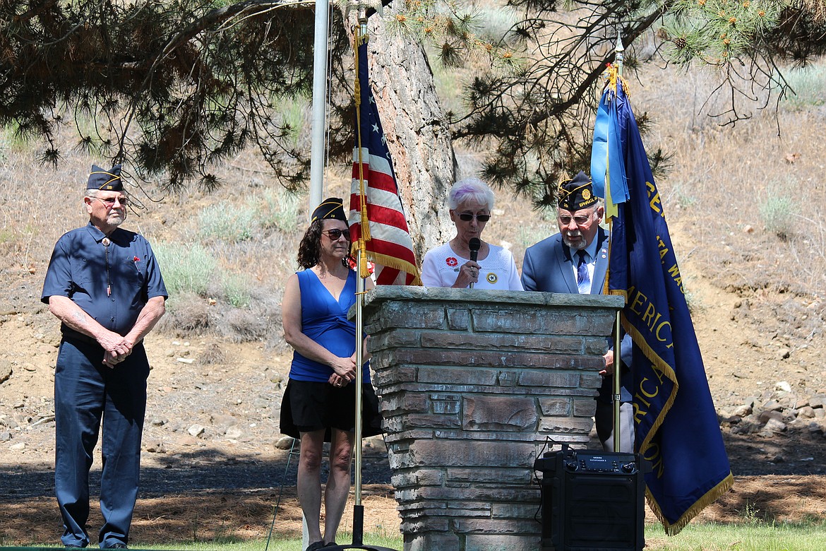 American Legion Post 28 auxiliary president Mardi Carroll, center, reads the names of veterans commemorated on the flags in the Aisle of Flags in the Ephrata Cemetery at a Memorial Day ceremony. She is flanked by Post 28 Commander Kimberly Thomas, left, and former commander Mike Montaney, right.