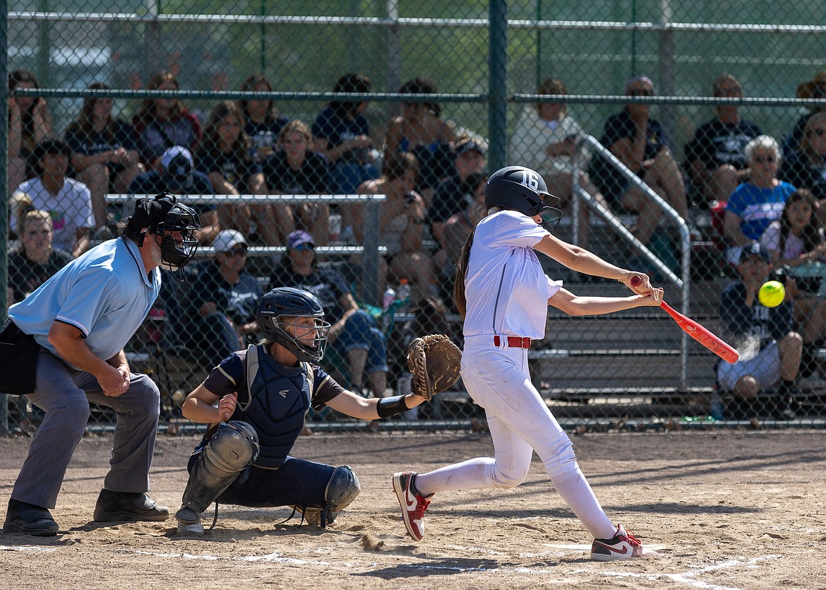 Othello senior Camryn McDonald, in white, swings at a pitch during the 2A State Softball Tournament.