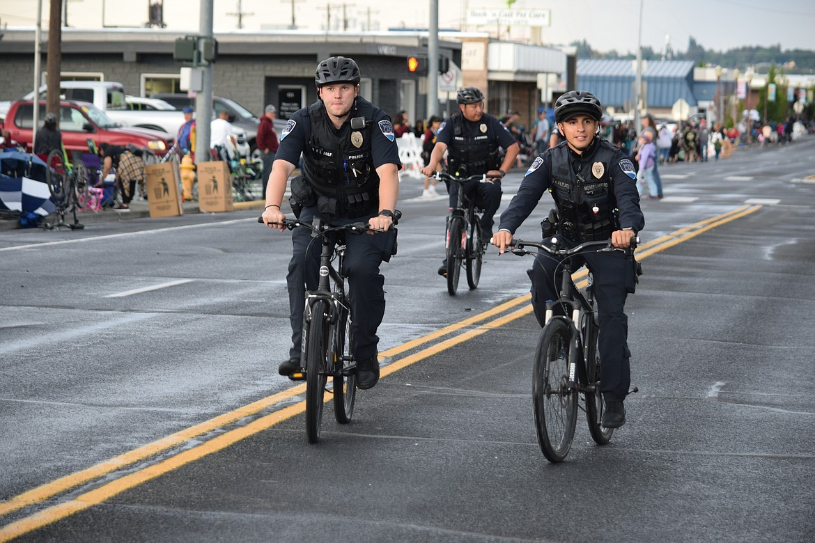 A trio of Moses Lake Police officers patrol down Third Avenue prior to the Grand Moonlight Parade on Saturday.