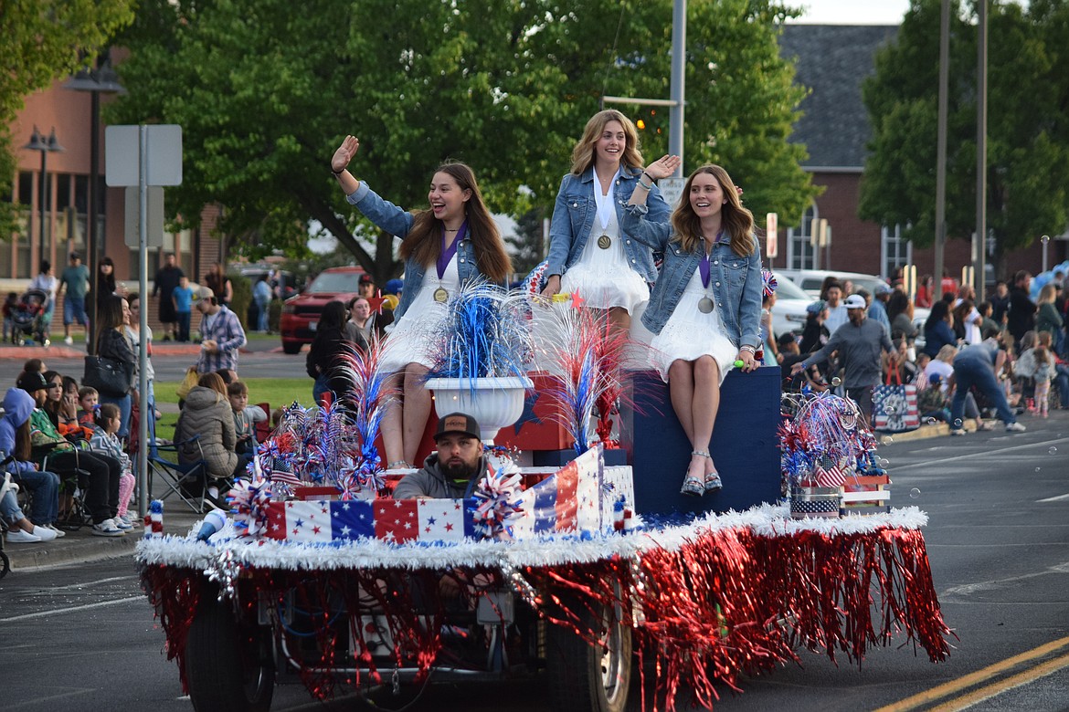 Distinguished Young Women of Moses Lake Addy Carlile (center) with First Runner Up Sydney Garza (left) and Second Runner Up Tori Moser (right) ride down Third Avenue during the Grand Moonlight Parade on Saturday.