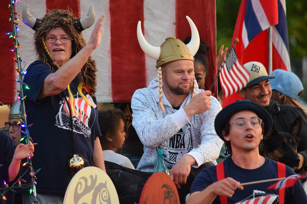 Members of the Sons of Norway wave from their viking longboat float in the Grand Moonlight Parade on Saturday.