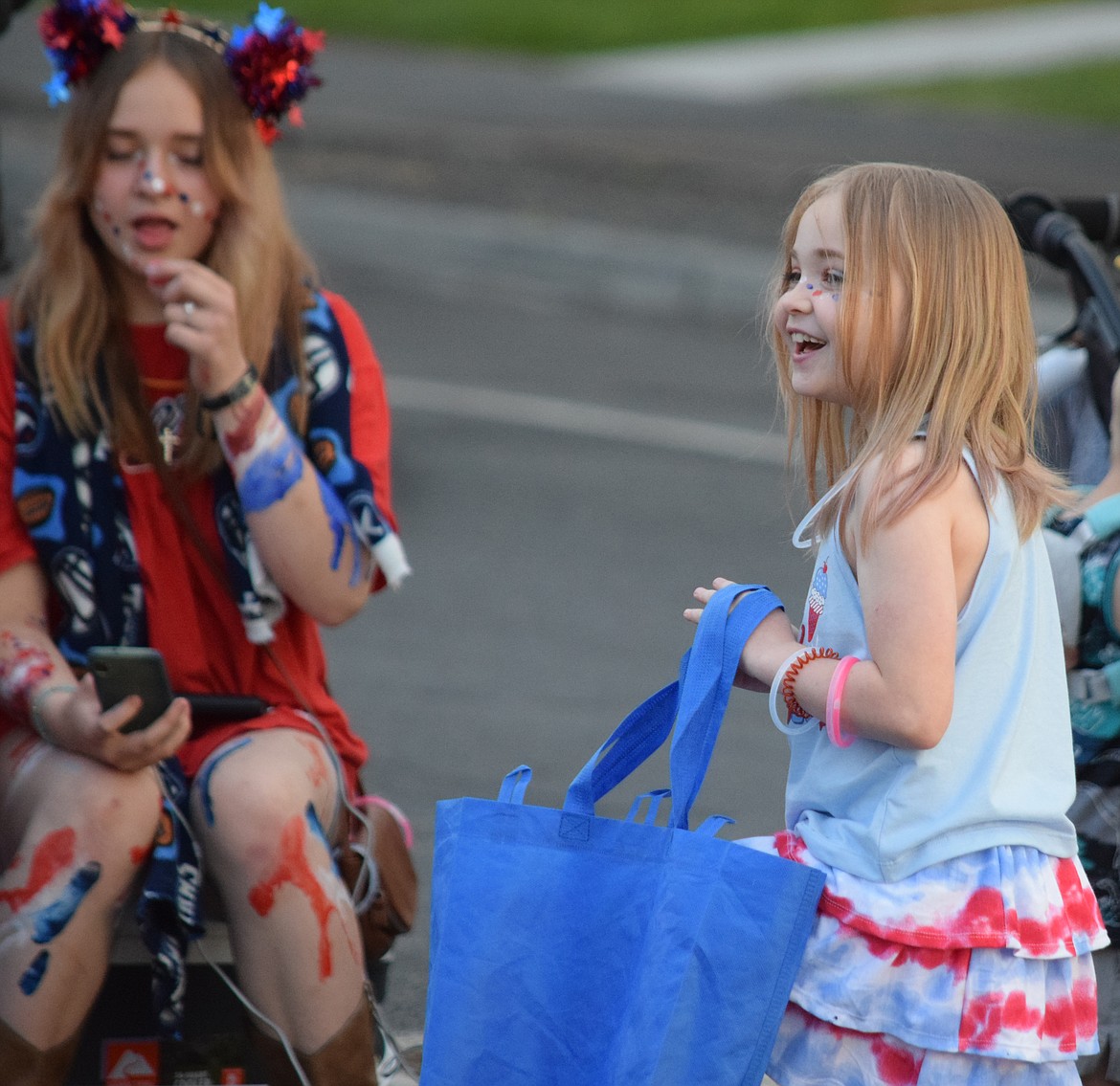 A girl enjoys the Grant Moonlight Parade — and picked up a lot of candy — along Third Avenue on Saturday.