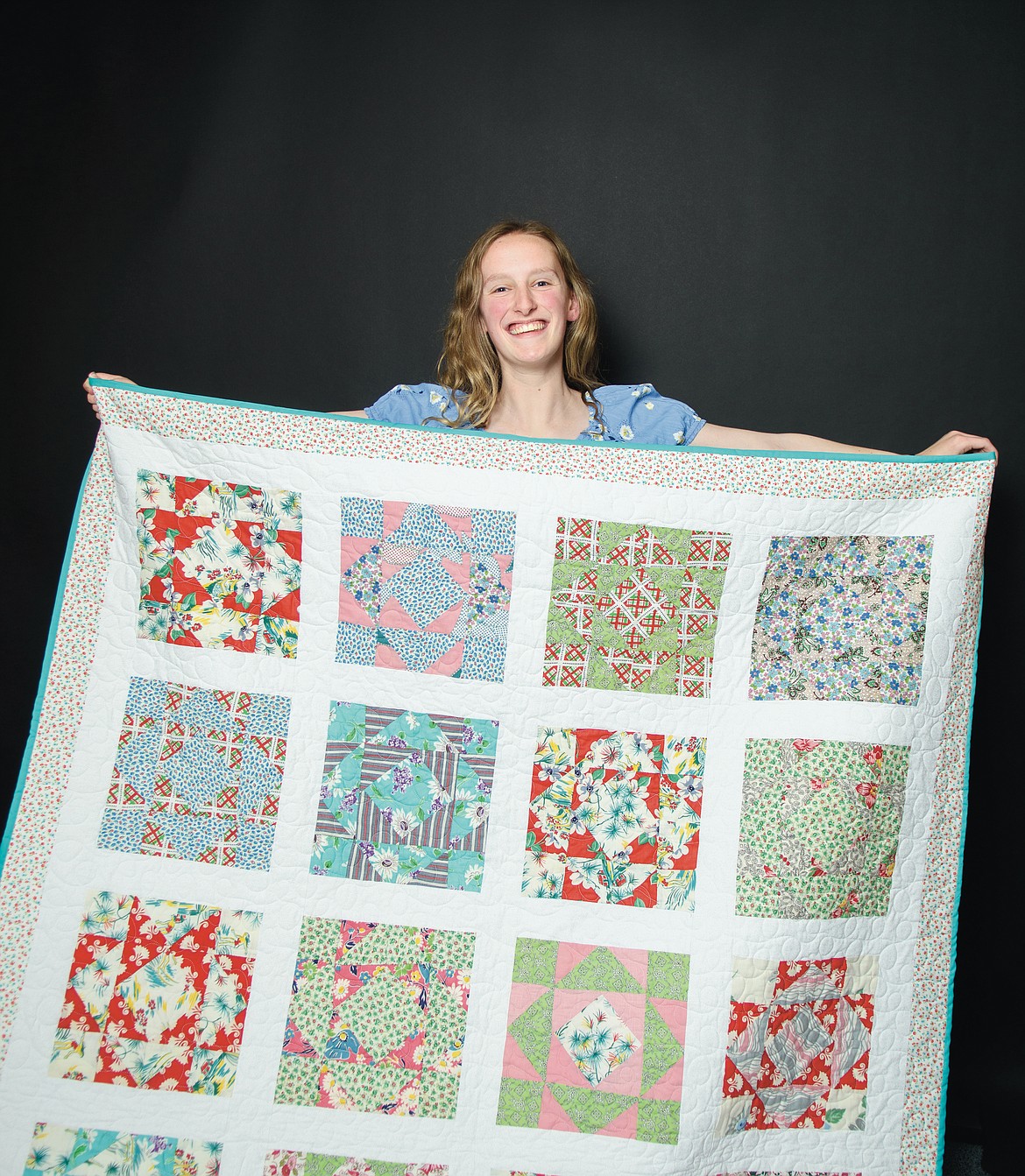 Madison Ypma with her quilt made from blocks sewn from Depression-era flour sacks. (Chris Peterson photo)