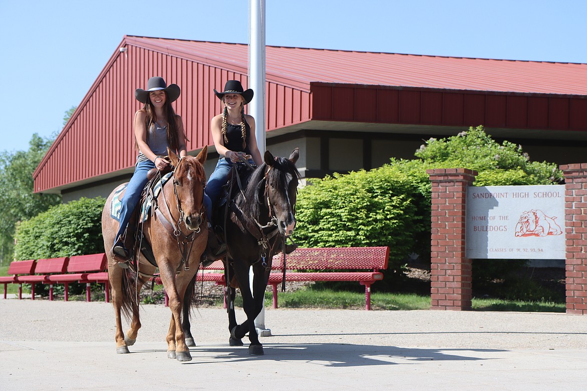 Sandpoint High School seniors Taylor Peck, left, and Kelly Whitney took advantage of an archaic Idaho law that allows students to ride their horses Katie and Newt to class during the last week of school. The law also requires administrators to take care of the animals while the students attend class.