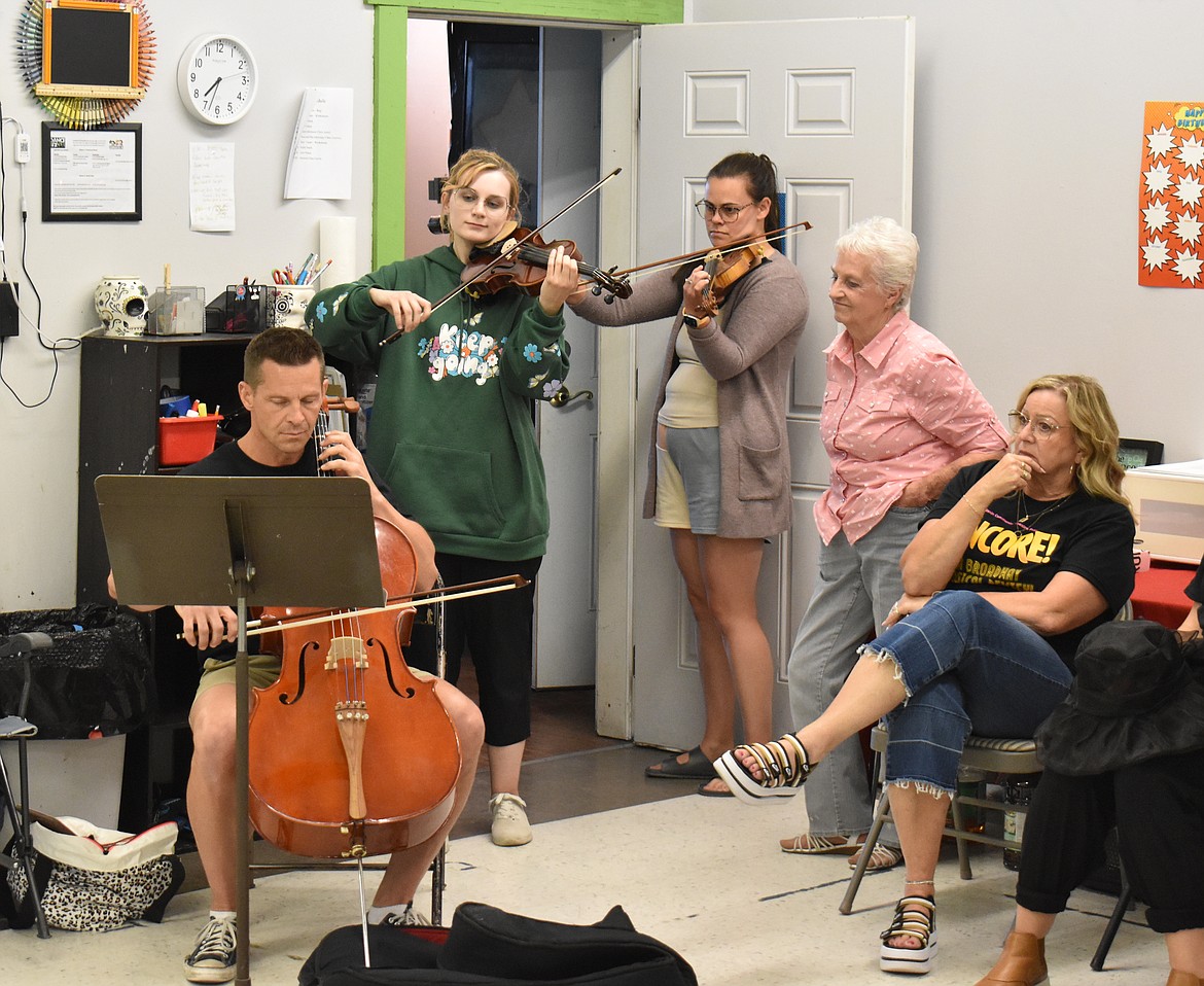 From left: Toby Black, on cello, and Katerena Jenson and Hannah Ahmann on violin play “Nearer My God to Thee” as  LaRene Black and Marion Wyman look on at a rehearsal of Basin Community Theatre’s “Encore! A Broadway Review.”