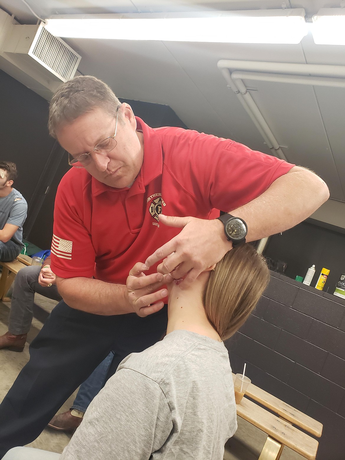 Northern Lakes Fire District Deputy Fire Marshal Chris Larson applies makeup to a Lakeland High School senior Friday morning for a mock DUI crash.