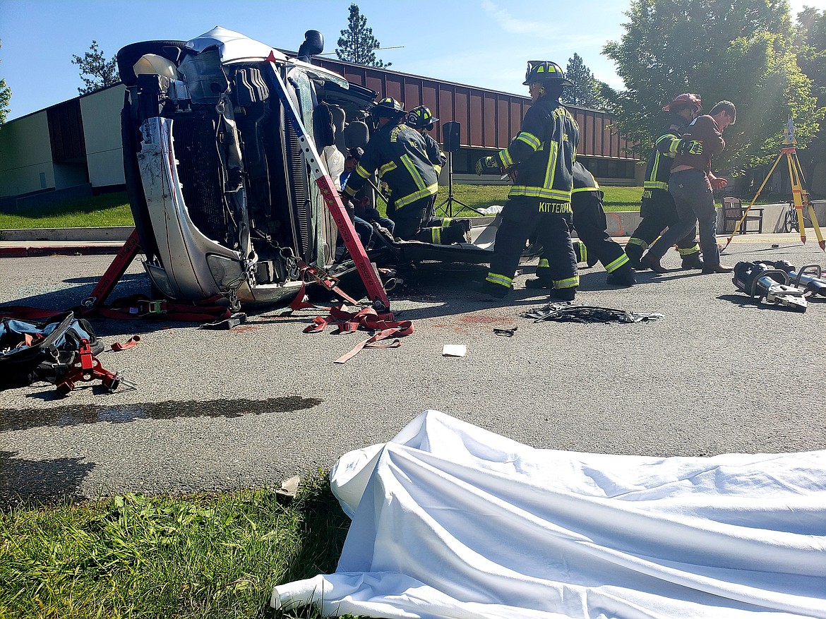 Firefighters remove Lakeland High School seniors from a minivan Friday during a DUI crash demonstration. The feet of Deegan Chambers can be seen beneath a sheet, after he was determined to be "dead on arrival" during the staged crash, which involved pills laced with fentanyl.
