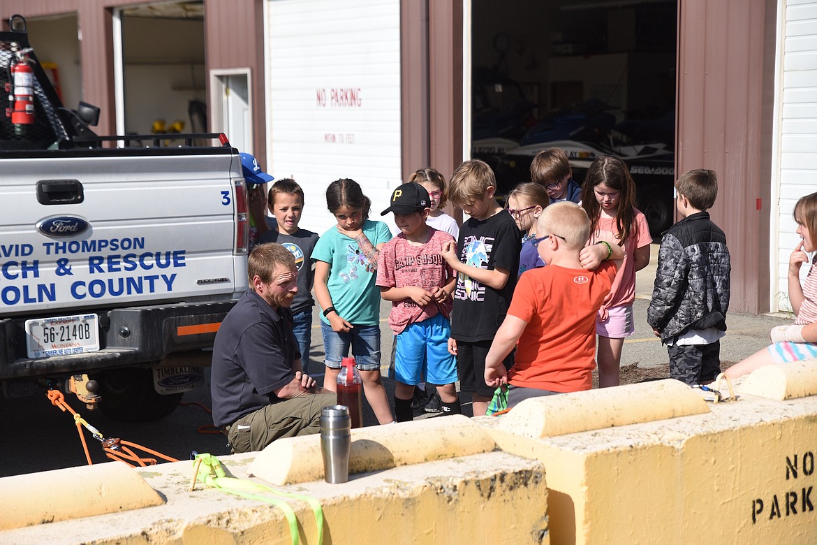 David Thompson Search and Rescue's Sam Pifer explains to the Libby second grade class how a rope system can be used to rescue or move large objects in dangerous terrain at Riverfront Park on Friday, June 2. (Scott Shindledecker/The Western News)