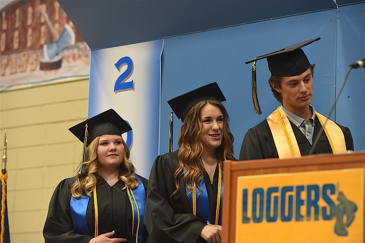 From left, class Salutatorian MacKinzie Mills, co-Valedictorians Jenavie Hammond and Trevor Collins watch as their fellow Libby High School Class of 2023 graduates receive their diplomas during ceremonies on Saturday, June 3, in Ralph Tate Gymnasium. (Scott Shindledecker/The Western News)