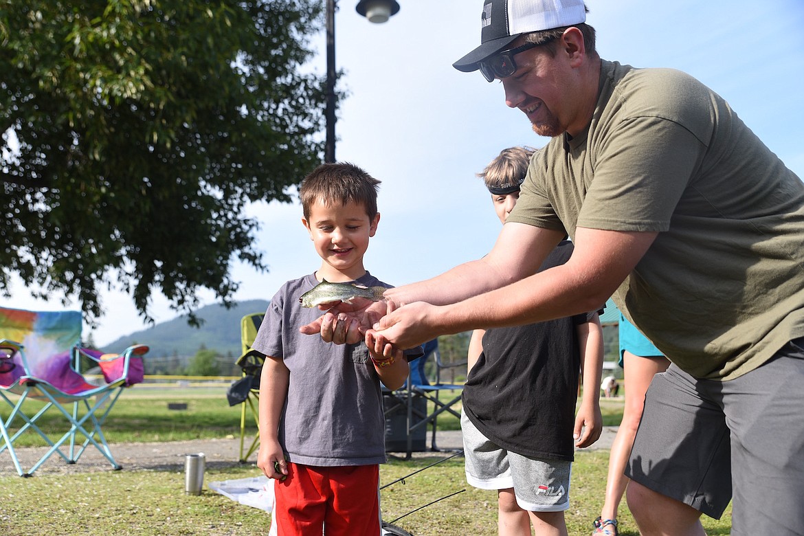 Kody Hoffman holds a trout his son, Karter, caught at the 19th annual Troy Kids’ Fishing Day at the Troy Community Pond at Roosevelt Park. (Scott Shindledecker/The Western News)