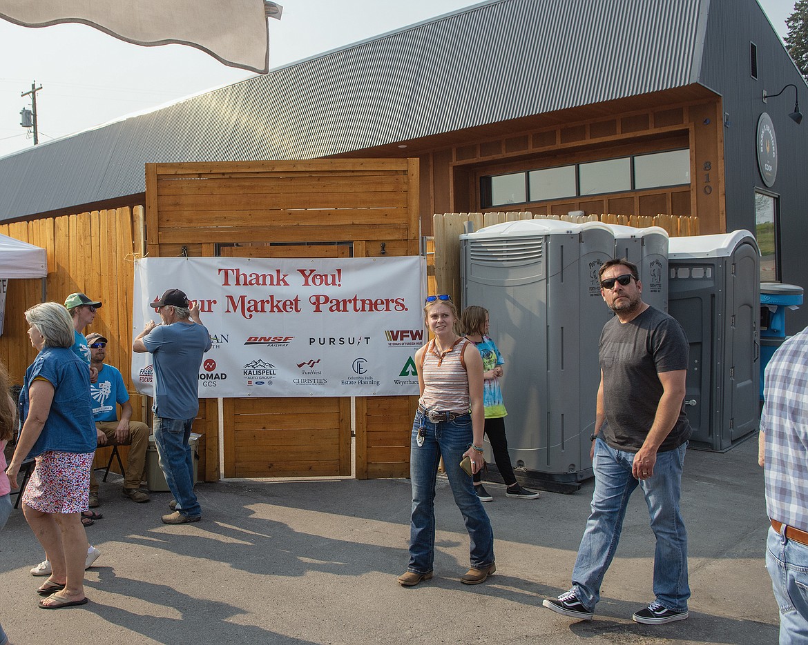 People stroll through the Columbia Falls Community Market on May 18. The Coop is in the background. (Chris Peterson/Hungry Horse News)