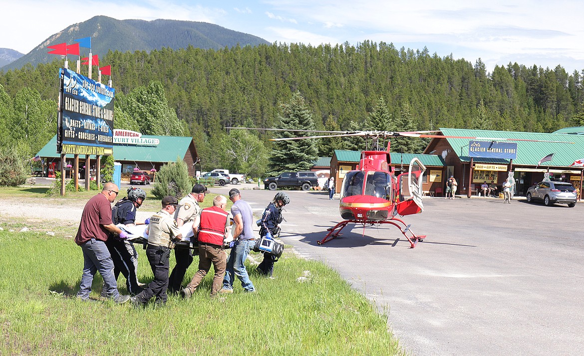 Emergency personnel carry an injured person to the ALERT helicopter. (JP Edge photo)