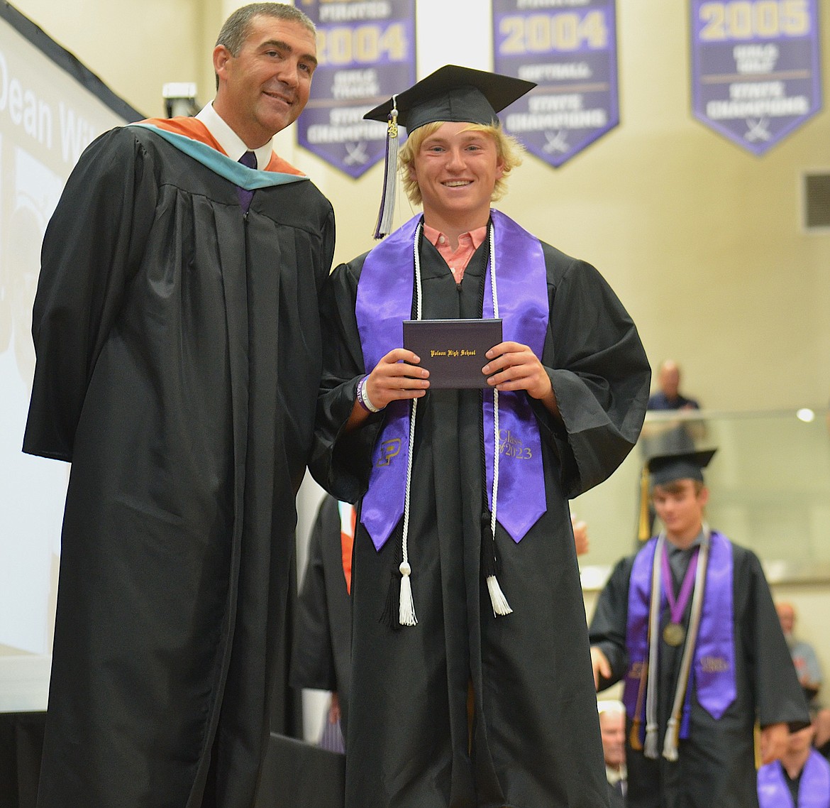 Polson High principal Andrew Fors congratulates Colter Wilson, with brother Jarrett Wilson next in line, during Saturday's graduation. (Kristi Niemeyer/Leader)