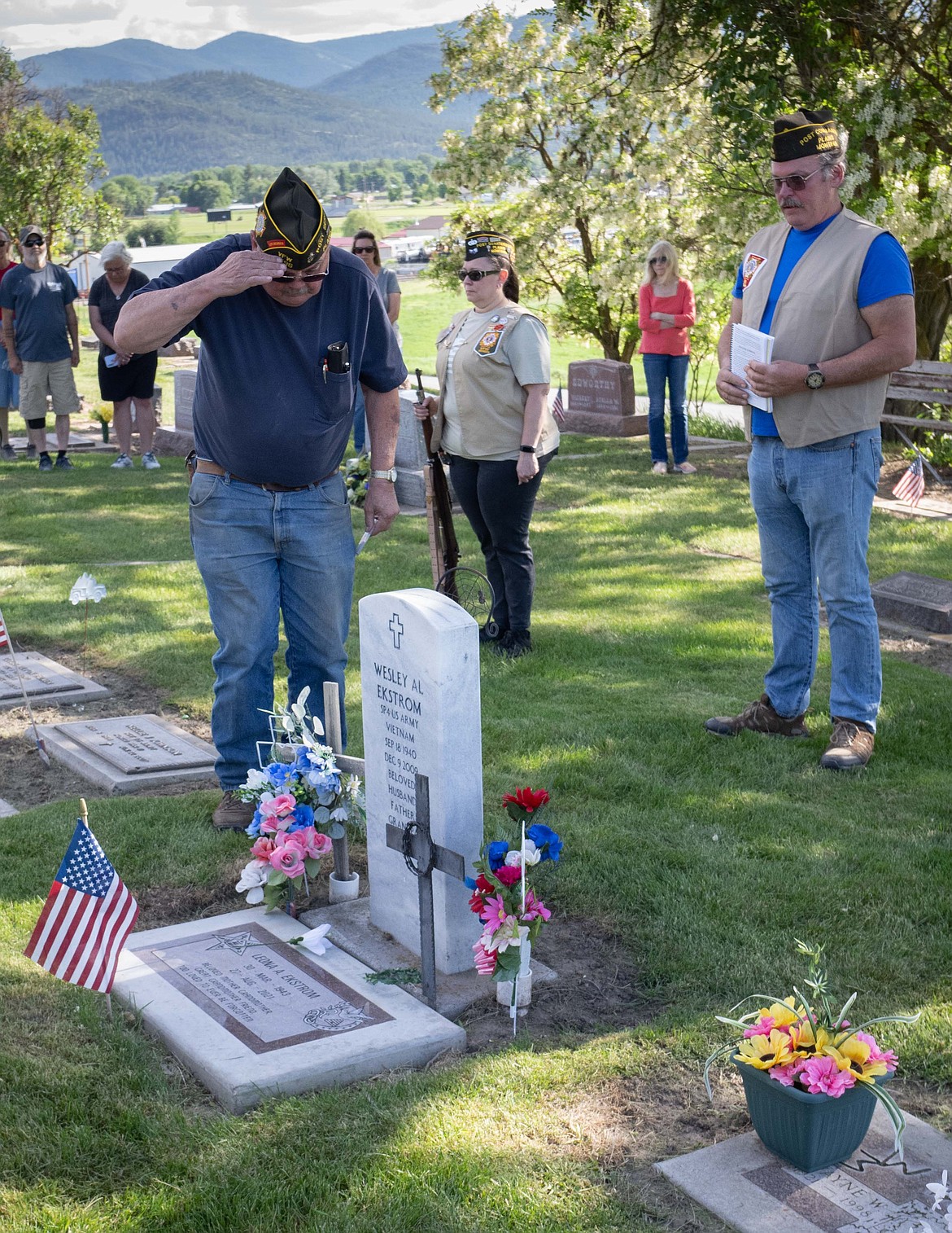 VFW member Will Beck salutes over the grave marker of a veteran buried in the Plains Cemetery as quartermaster Heather Allan and Post Commander Ron Kilbury stand at attention during Memorial Day Ceremonies last week in Plains. (Tracy Scott photo)