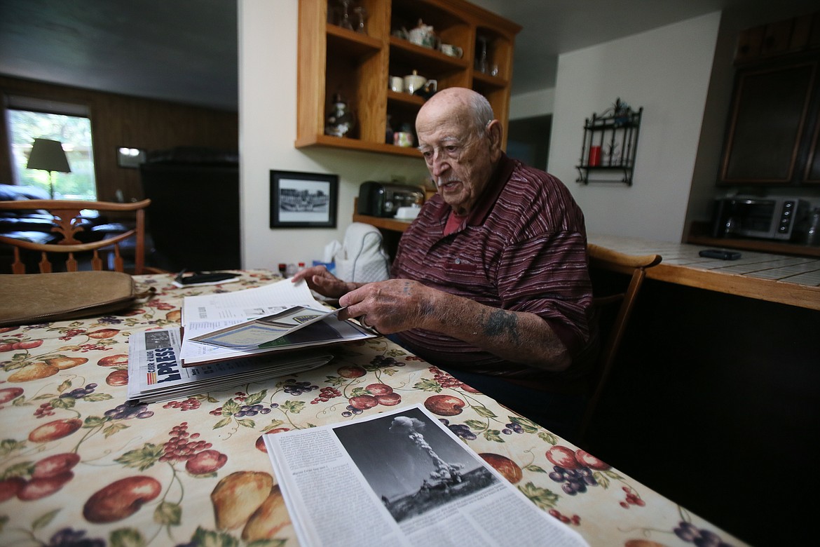 A mushroom cloud from Operation Tumbler–Snapper is seen in a magazine photo Tuesday as Mac McCormack looks through photos and clippings at his Coeur d'Alene home. In March 1955, McCormack, a Marine, was one of the first to witness the power of the atomic bomb. He has been recognized for his service with an Atomic Veterans Commemorative Service Medal and the Atomic Veteran’s Service Certificate.